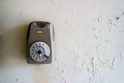 Old broken telephone on a wall 