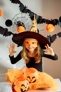 Portrait of smiling girl with arms raised during halloween