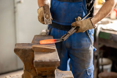 Close up view of heated metal and anvil. the blacksmith in the production process of metal products