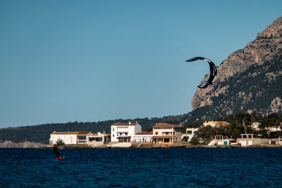 Sea by buildings against clear sky