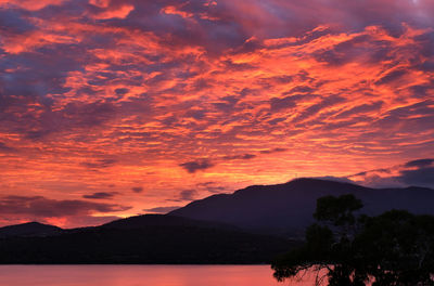 Scenic view of silhouette mountains against orange sky