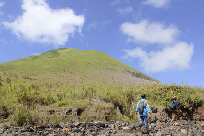 Rear view of man on mountain against sky