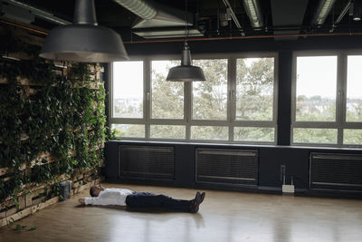 Businessman in green office lying on the floor