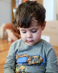 Portrait of a young boy of three playing with a toy in the living room