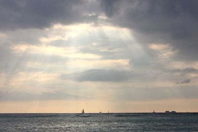 Scenic view of sea against cloudy sky during sunset