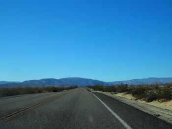 Empty road along countryside landscape