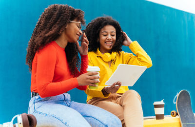 Smiling young females looking at digital tablet outdoors