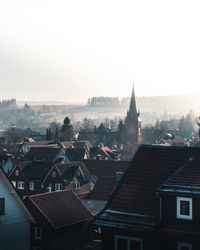 High angle view of townscape against foggy sunrise