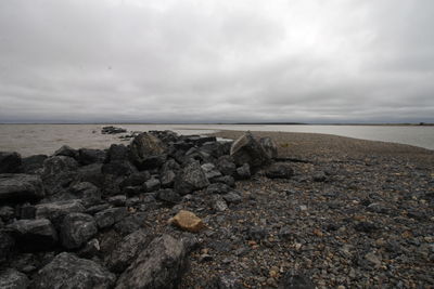 Rocks on beach against sky