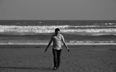 Man standing on sand against sea