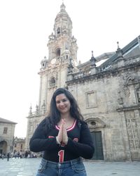 Portrait of beautiful woman standing against building in city