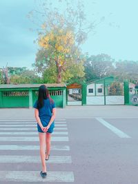 Full length of woman standing on road