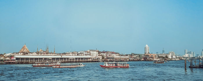 Boat moored in sea against clear blue sky