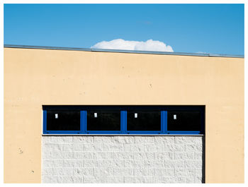 Closed door of building against blue sky