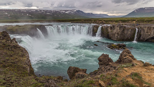Wide-angle view of the thundering godafoss waterfalls during a brief icelandic summer