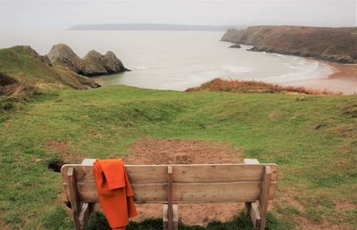 Scenic view of bench overlooking cliffs and sea 