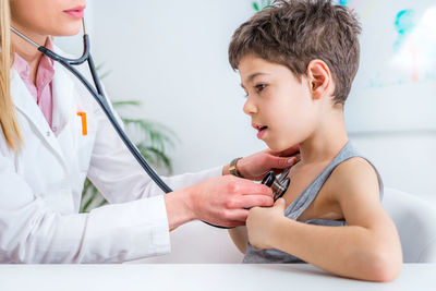 Female doctor examining boy at clinic