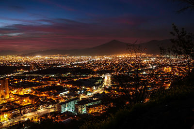 High angle view of illuminated city against sky at night