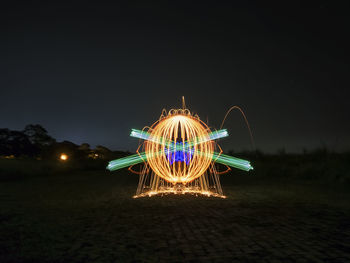 Illuminated light trails against sky at night