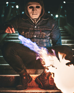 Midsection of man holding illuminated lighting equipment