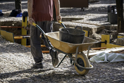 Rear view of man working on zebra crossing in city