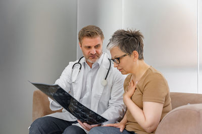 Side view of doctor using digital tablet while sitting at home