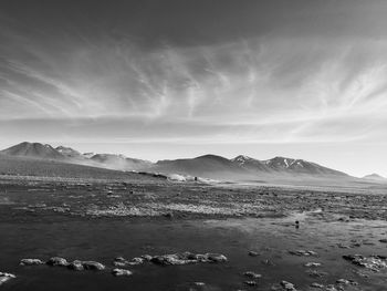 Black and white photo of lagoon with mountains in atacama desert