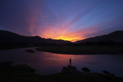 Evening landscape, rivers, mountains, dark blue sky, beautiful clouds, shadows of people