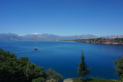Scenic view of bay against clear blue sky