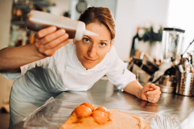 Female chef is adding ingredients to make a dessert
