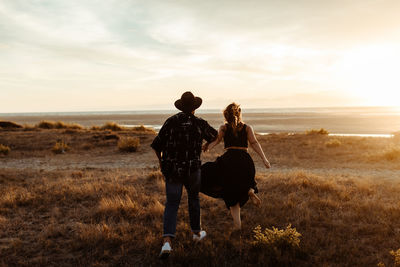 Rear view of women on field during sunset