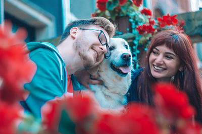 Portrait of smiling young couple with golden retriever 