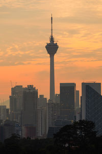 Modern buildings against sky during sunset