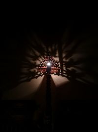 Low angle view of illuminated carousel against sky at night