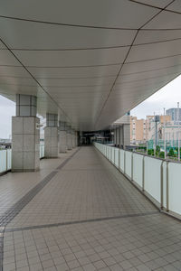 Empty footpath amidst buildings in city