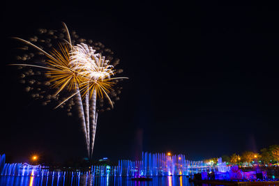 Fountain and fireworks display against sky