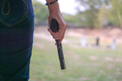Midsection of woman holding gun