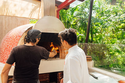 Chef looking for the temperature in a wood-fired oven