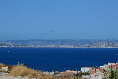 High angle view of townscape by sea against clear sky