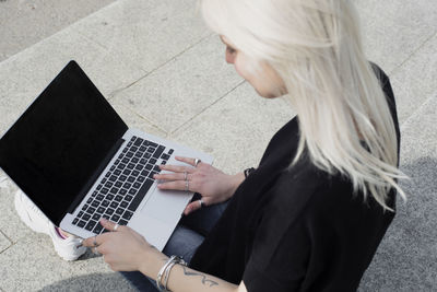 High angle view of woman using laptop in city