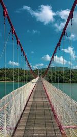 Empty footbridge against sky