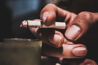 Close-up of hand holding cigarette