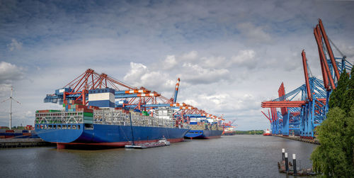 Panorama of a harbour basin with large container bridges and container ships