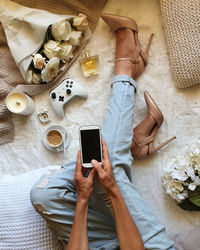 High angle view of woman holding phone relaxing at home