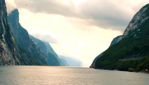 Scenic view of sea and mountains against sky