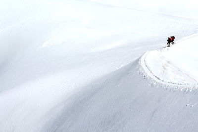 Tourists on snow covered mountain