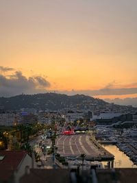 High angle view of street and buildings against sky during sunset