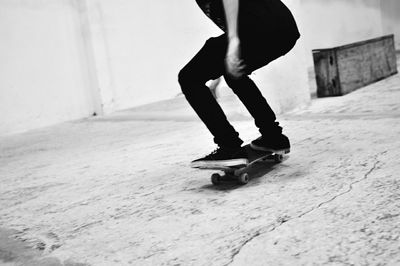 Low section of person skateboarding on street