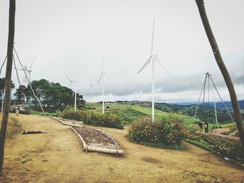 Panoramic view of wind turbines against sky