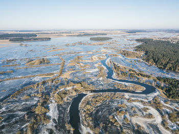 Aerial view of land and sea against clear sky